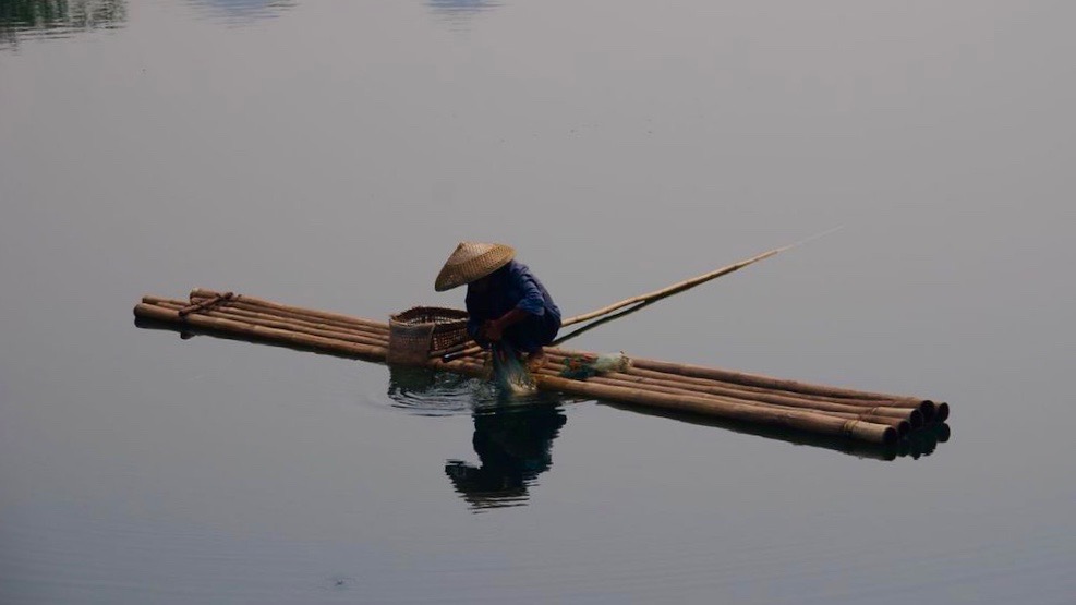 Fisherman on bambooboat China