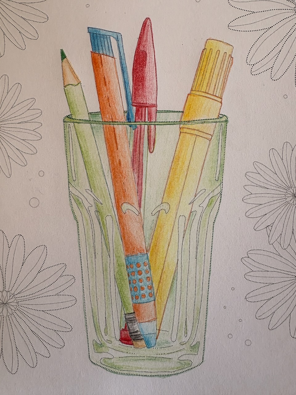 A Mandala of a green glass with pencils and pens in it